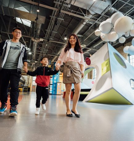Couple walking through a museum with their child holding his hand in Manitoba ca