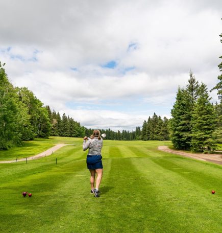 Woman teeing off at Clear Lake Golf Course.