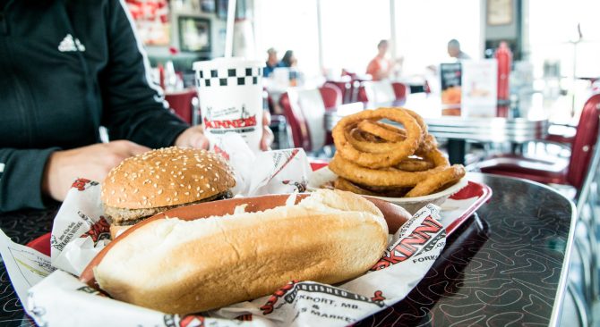 diner food on table from skinners. hamburger, hot dog, and onion rings with a drink cup from skinners in manitoba canada