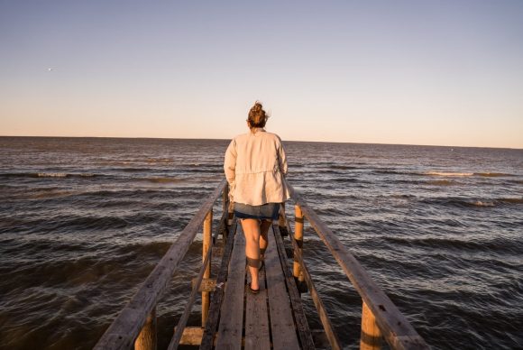 Person walking out on pier over Lake Winnipeg at Matlock Beach