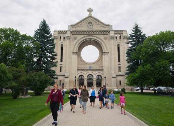Group of people enjoying a walking tour in front of the St. Boniface Cathedral in Winnipeg